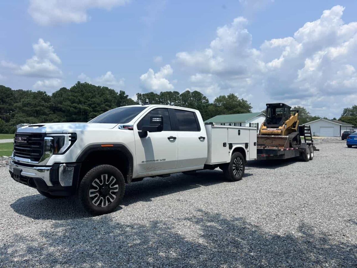 Precision Hauling & Grading's truck and trailer hauling a skid steer in Eastern North Carolina.